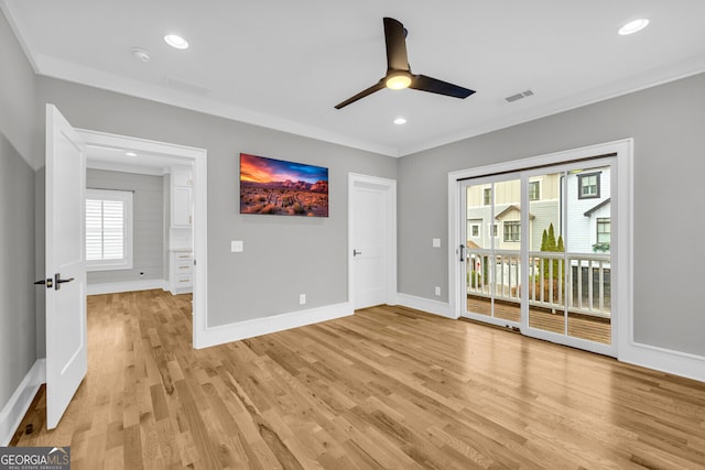 spare room with ceiling fan, crown molding, and light wood-type flooring