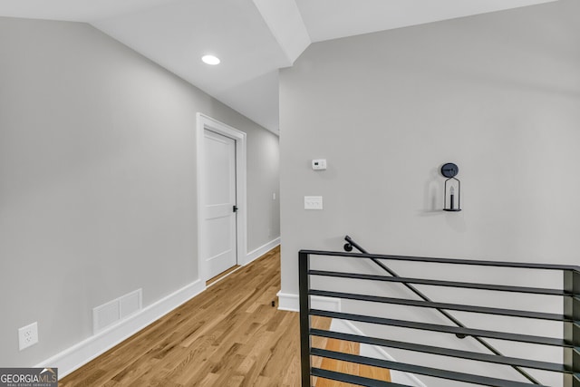 stairway featuring lofted ceiling and hardwood / wood-style flooring