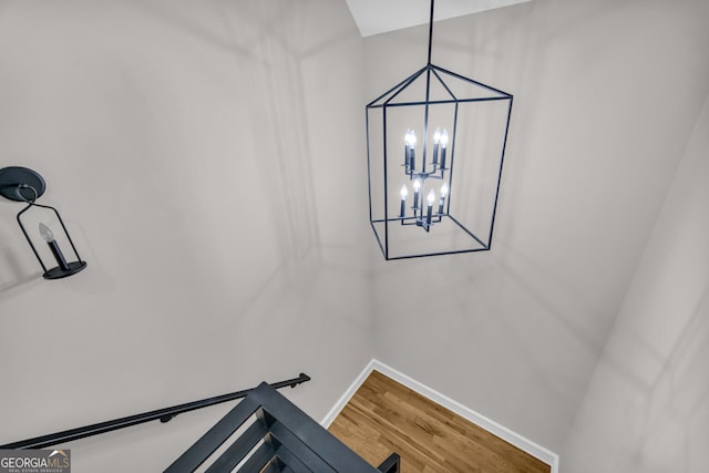 stairway with a chandelier and hardwood / wood-style floors