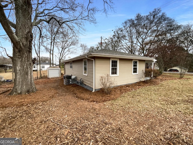 view of property exterior with central AC, a garage, and an outdoor structure