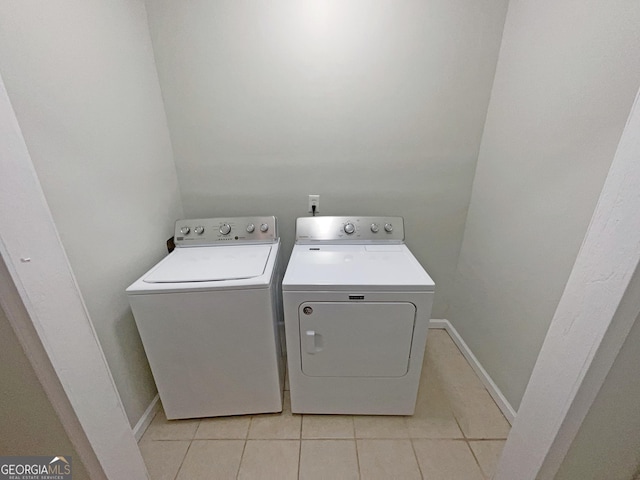 clothes washing area featuring washing machine and dryer and light tile patterned floors