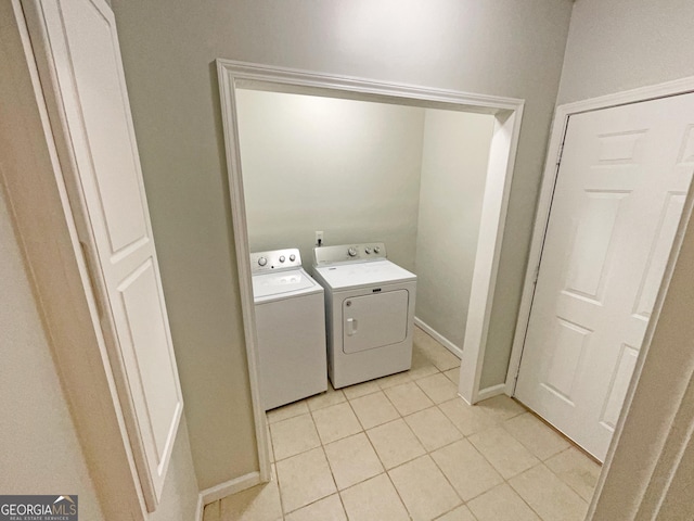 clothes washing area with light tile patterned floors and separate washer and dryer