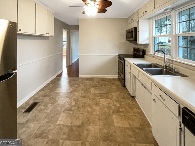 kitchen featuring ceiling fan, sink, white cabinetry, and stainless steel appliances