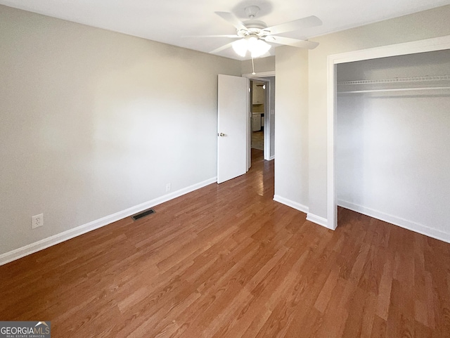 unfurnished bedroom featuring hardwood / wood-style floors, ceiling fan, and a closet