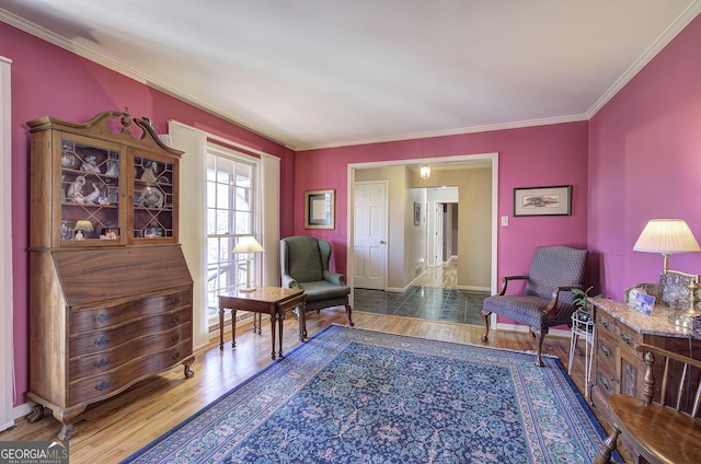 living area with hardwood / wood-style flooring and ornamental molding