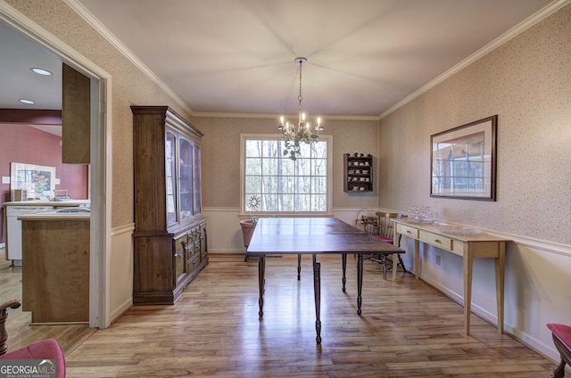 dining room featuring an inviting chandelier, ornamental molding, and light wood-type flooring