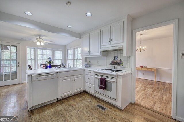 kitchen featuring white appliances, light hardwood / wood-style floors, decorative backsplash, sink, and kitchen peninsula