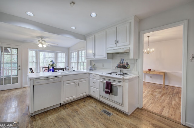 kitchen with white cabinetry, white appliances, under cabinet range hood, backsplash, and light wood-style floors