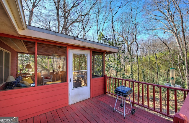 wooden terrace featuring a sunroom and grilling area