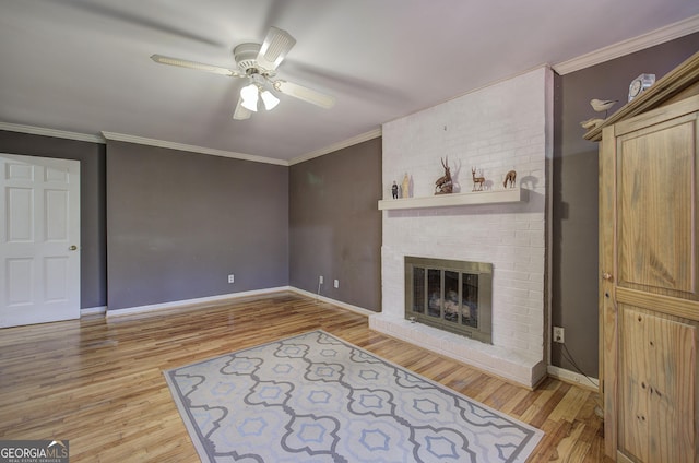 living room featuring ceiling fan, a brick fireplace, light hardwood / wood-style flooring, and crown molding