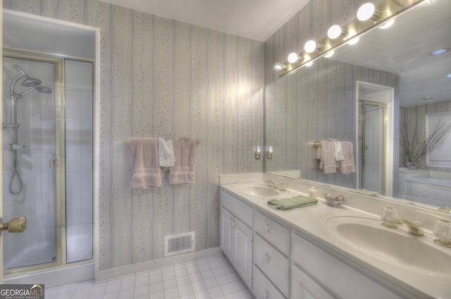 bathroom with a shower with shower door, vanity, and tile patterned flooring