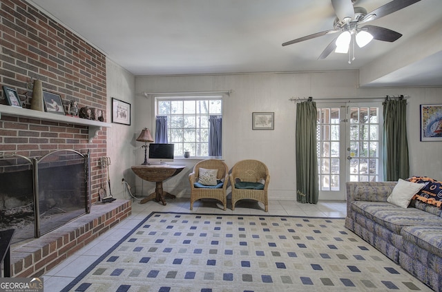 living room featuring ceiling fan, light tile patterned flooring, a healthy amount of sunlight, and a brick fireplace