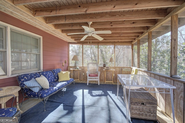 sunroom / solarium featuring ceiling fan, a healthy amount of sunlight, beam ceiling, and wooden ceiling