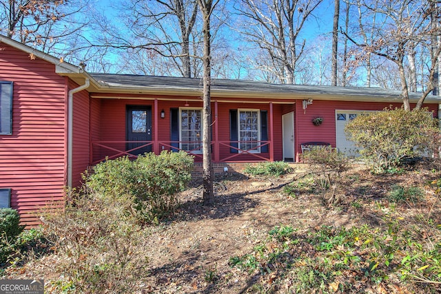 doorway to property featuring a garage and covered porch