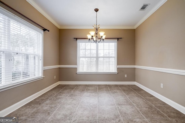 spare room with tile patterned flooring, ornamental molding, and a notable chandelier