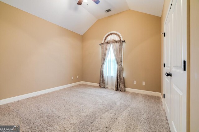 carpeted empty room with ceiling fan and vaulted ceiling