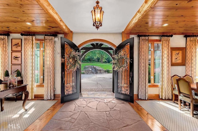 entrance foyer with french doors, plenty of natural light, and wood ceiling