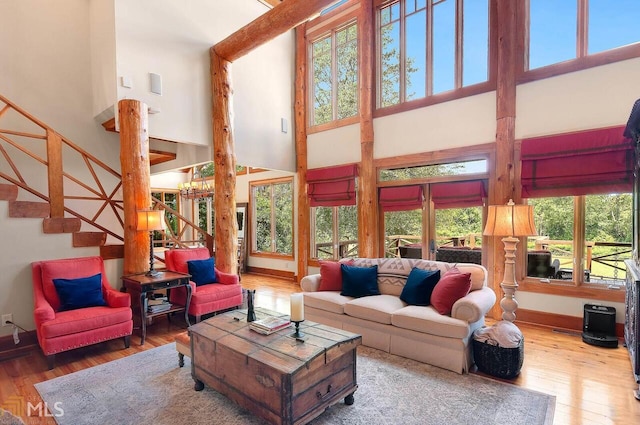 living room featuring a wealth of natural light, a towering ceiling, and hardwood / wood-style flooring