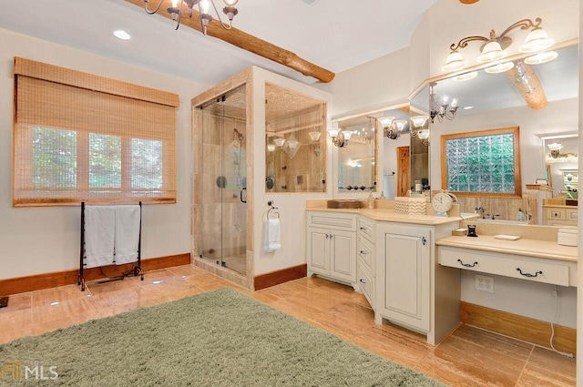 bathroom featuring tile patterned floors, vanity, a shower with shower door, and a notable chandelier