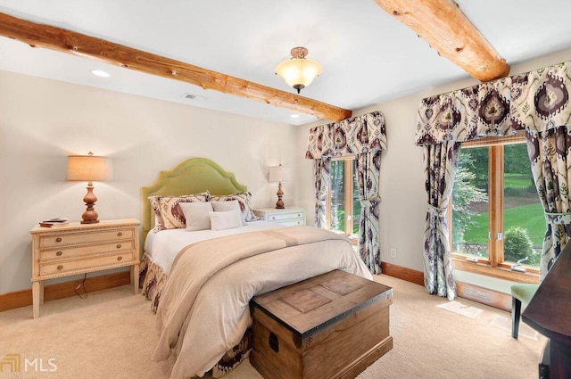 carpeted bedroom with beamed ceiling