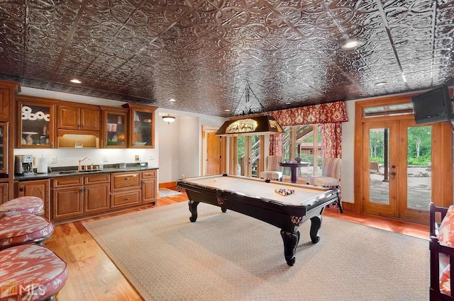 playroom featuring indoor wet bar, light wood-type flooring, billiards, and french doors