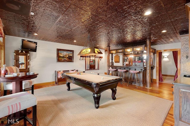 rec room featuring pool table, hardwood / wood-style flooring, and bar