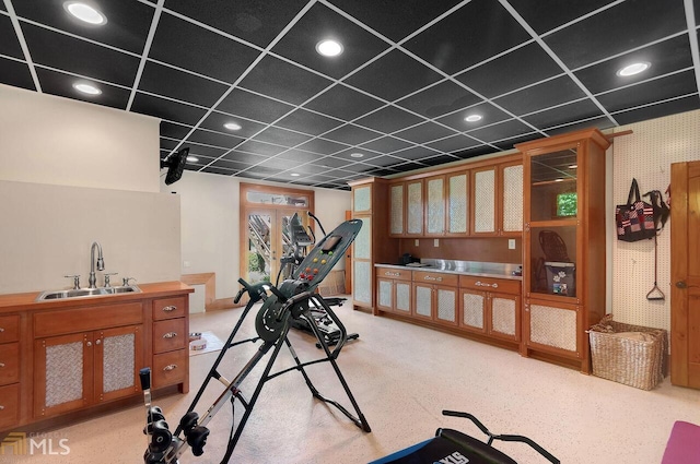 workout room featuring a paneled ceiling and sink