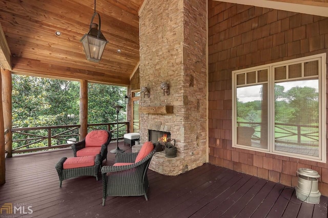 wooden deck featuring an outdoor stone fireplace