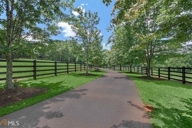 view of gate featuring a lawn and a rural view