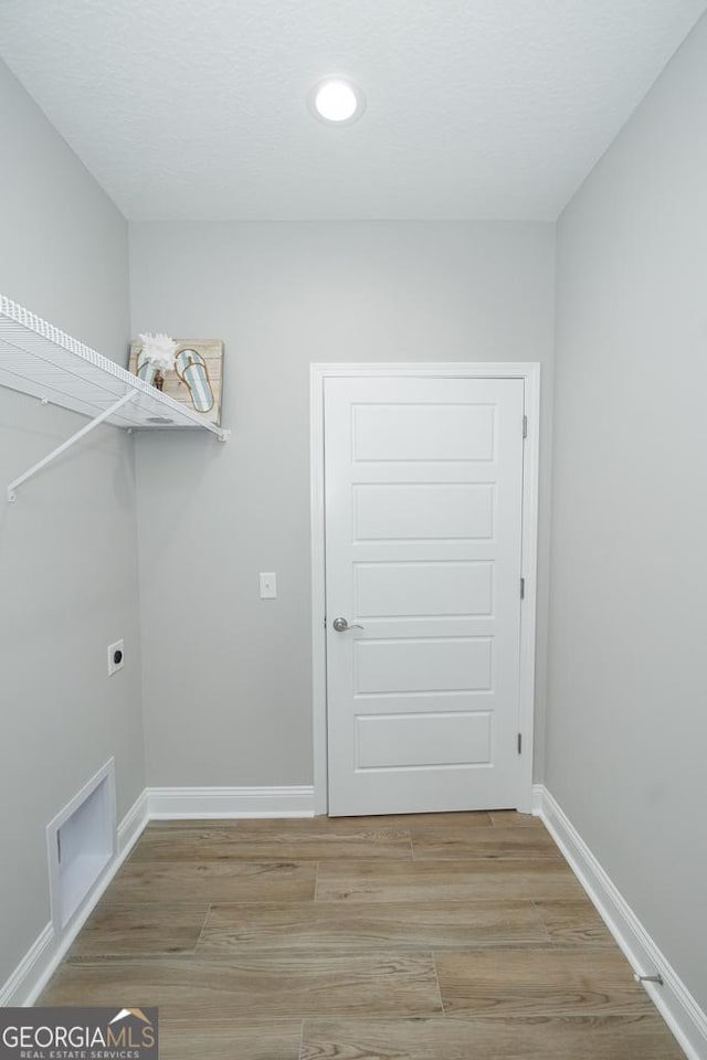 laundry room with electric dryer hookup and wood-type flooring