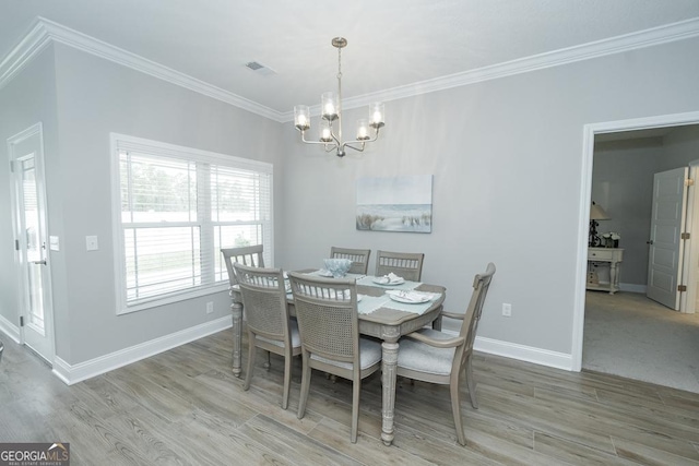 dining room featuring a chandelier, hardwood / wood-style floors, and crown molding