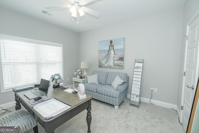 living room featuring light carpet, ceiling fan, and a healthy amount of sunlight