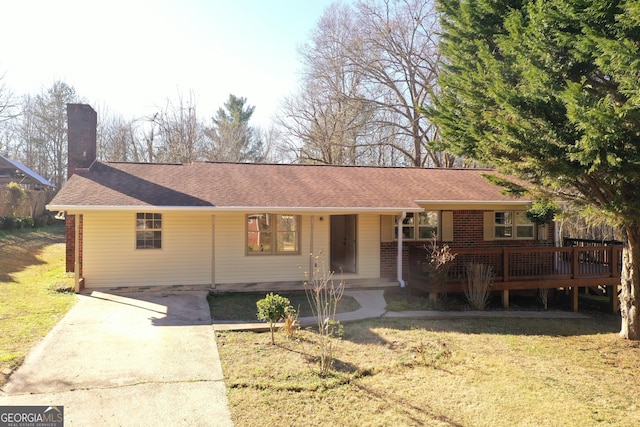 ranch-style house with a deck and a front lawn