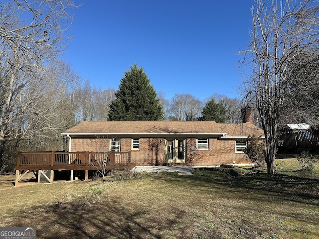 rear view of property with a deck and a yard