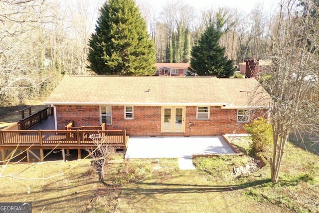 back of property featuring french doors, a deck, a patio area, and a lawn