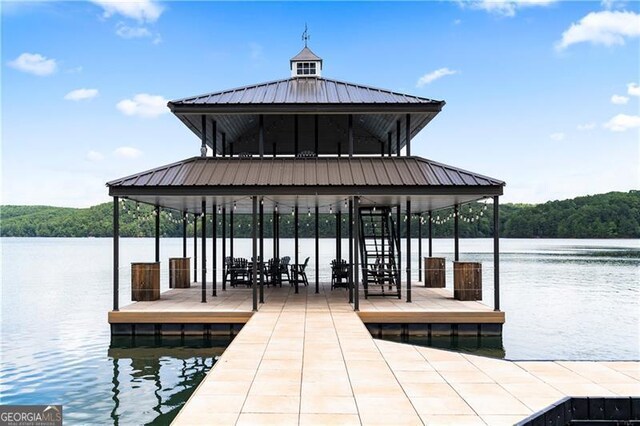 view of dock featuring a view of trees and a water view