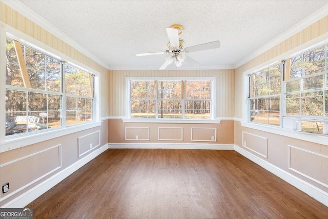 unfurnished sunroom featuring ceiling fan and plenty of natural light