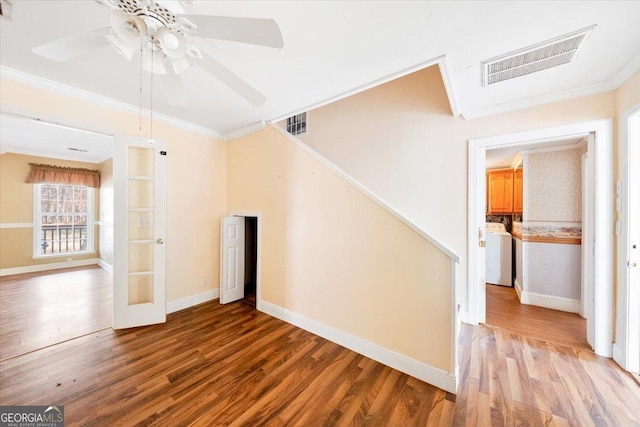 interior space with french doors, crown molding, hardwood / wood-style flooring, ceiling fan, and washer / dryer