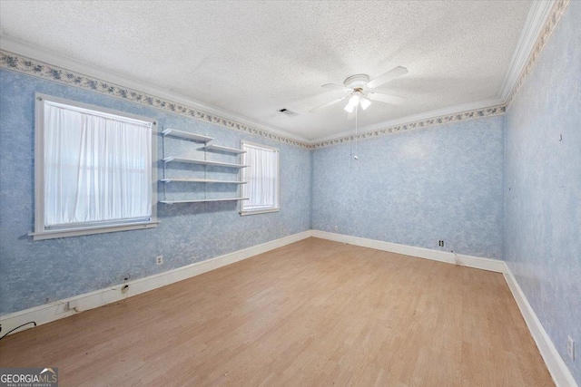 spare room featuring light hardwood / wood-style flooring, a textured ceiling, and ornamental molding