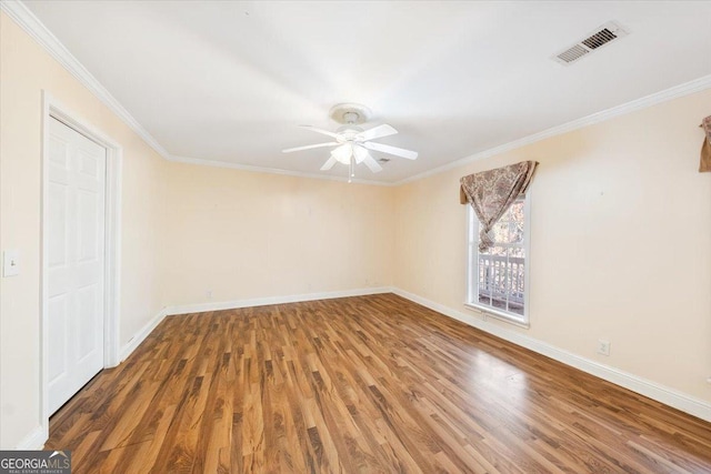 spare room with crown molding, ceiling fan, and dark wood-type flooring