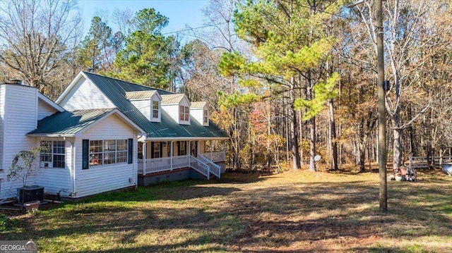 rear view of property with a porch, a yard, and cooling unit