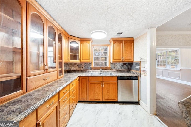 kitchen with backsplash, dark stone counters, sink, stainless steel dishwasher, and ornamental molding