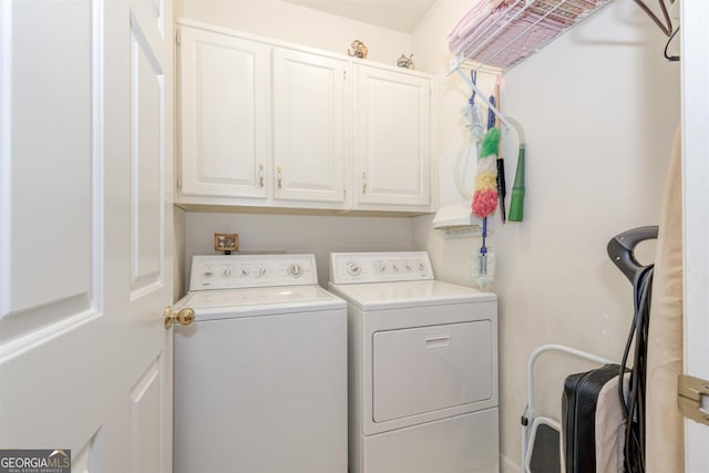 clothes washing area featuring cabinets and separate washer and dryer