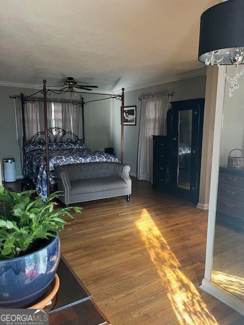 bedroom with hardwood / wood-style flooring and ornamental molding