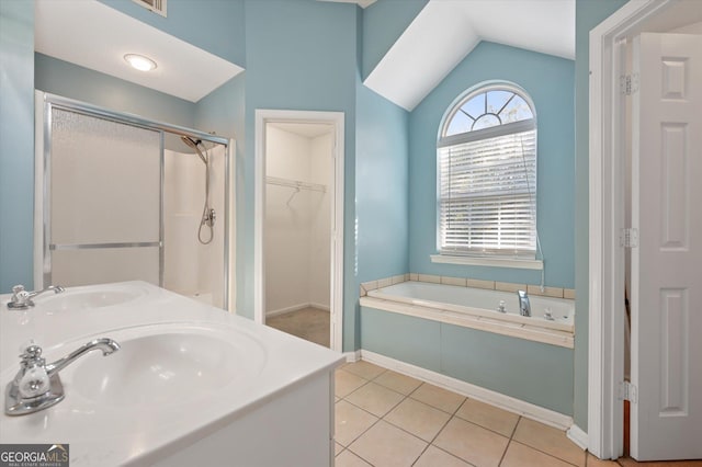 bathroom with sink, tile patterned flooring, vaulted ceiling, and plus walk in shower