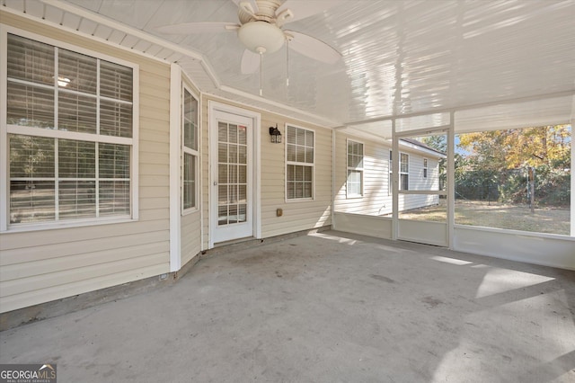 unfurnished sunroom with ceiling fan