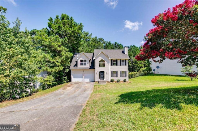 colonial inspired home featuring a garage and a front lawn