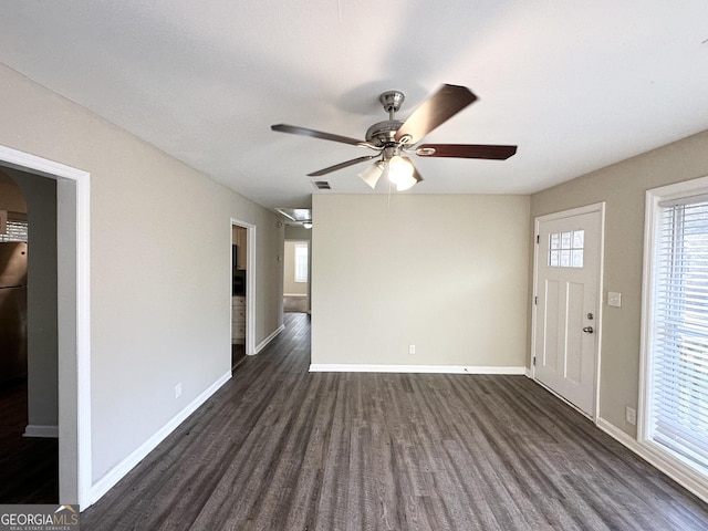 interior space with ceiling fan and dark hardwood / wood-style flooring