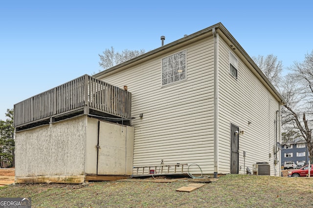 view of side of property featuring a balcony and cooling unit