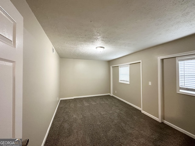 carpeted spare room with a textured ceiling